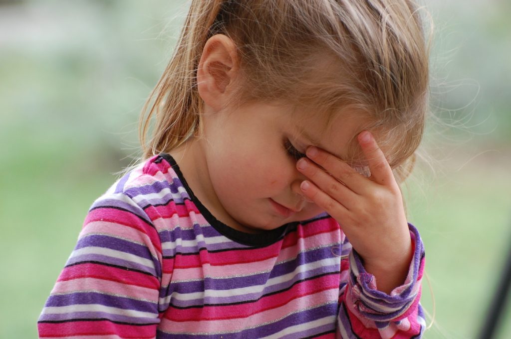 Migräne bei Kindern - Mädchen hat Kopfschmerzen