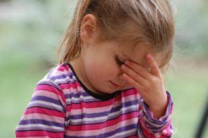 Migräne bei Kindern - Mädchen hat Kopfschmerzen